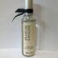 Olive Wood Room Spray - 100ml shown capped with black ribbon against a grey background