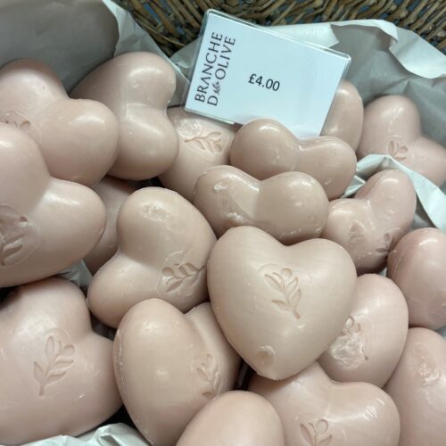 A basket full of 100g heart shaped pink rose fragranced soaps, slightly dented.