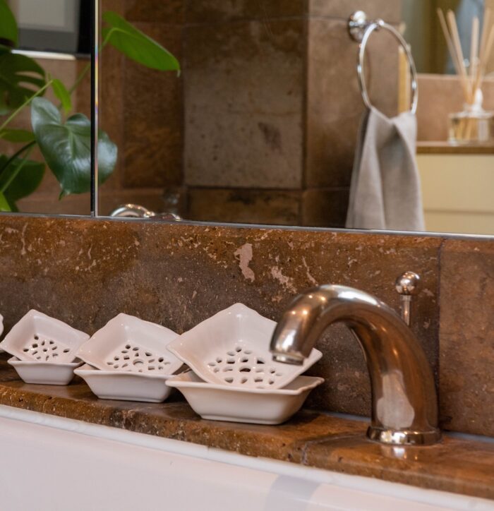 Branche d'Olive two layered draining rectangular soap dishes displayed beside a decorative basin with mirror above