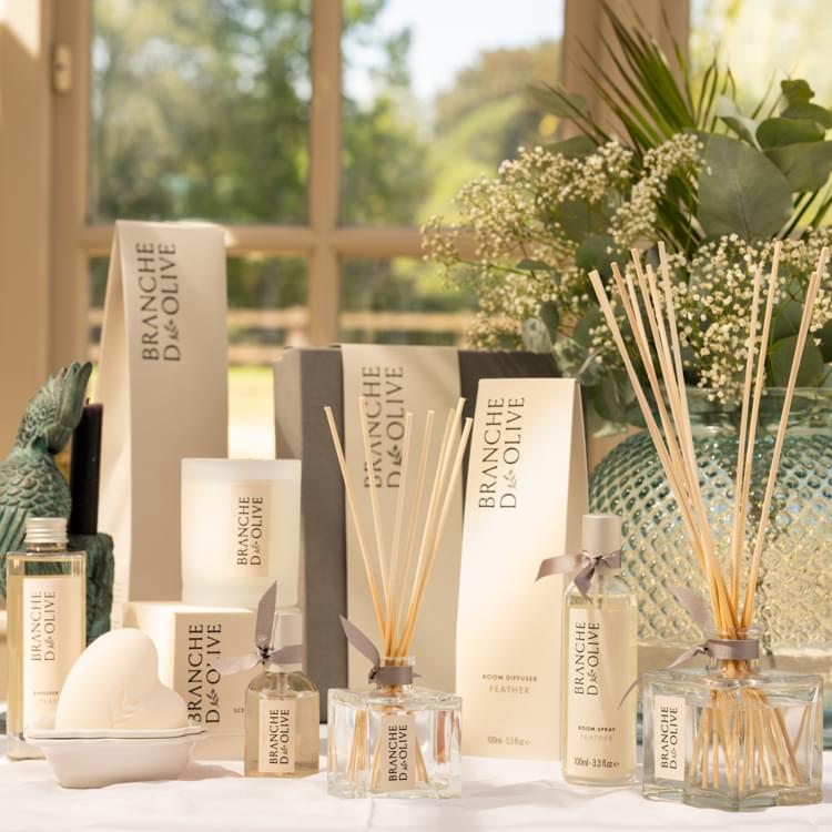 Branche d'Olive's Feather home fragrance range mood shot with flowers taken against a garden backdrop