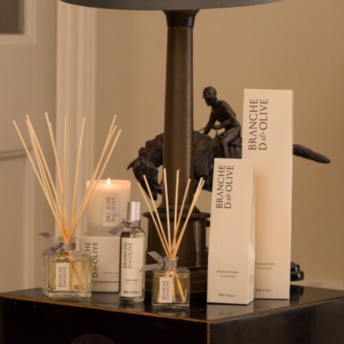 Branche d'Olive Feather large and small Room Diffusers, Room Spray and Scented Candle on a dark wooden table